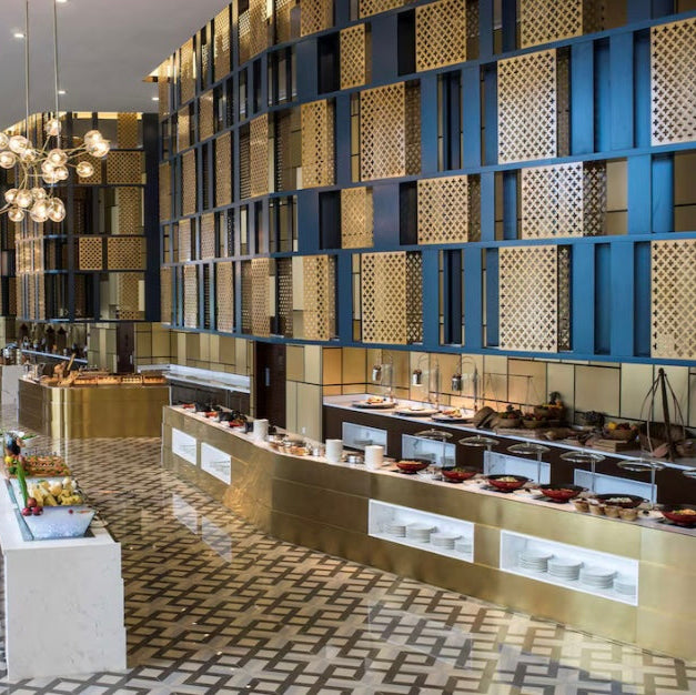 Modern kitchen or bakery interior with geometric wall design and patterned floor.